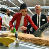 Ein Junger Mann aus dem Irak bei seiner Berufsausbildung arbeitet an einer Hobelbank