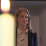 Frau hinter einer weißen leuchtenden Kerze