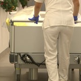 Ein Krankenpfleger schiebt ein Krankenbett.