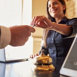 Eine Rezeptionisten im Hotel gibt einem Gast die Zimmerkarte.