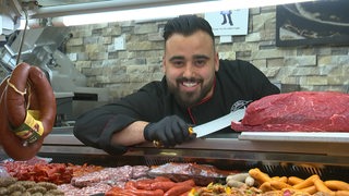 Der Fleischer Beytullah Saglik an der Frischetheke im Supermarkt. 