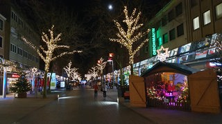 Bäume mit Lichterschmuck und einzelne Weihnachtsmarktbuden auf Abstand in Bremerhaven 2020
