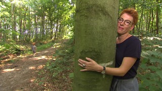 Bianca Lutter umarmt im Hasbrucher Wald einen Baum.