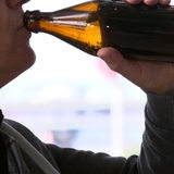 Ein Mann trinkt aus einer Bierflasche.