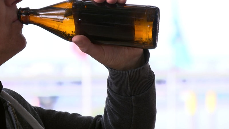 Ein Mann trinkt aus einer Bierflasche.