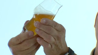 Ein kleines Bierglas wird geschwenkt.