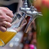Eine Bedienung zapft ein Bier. 
