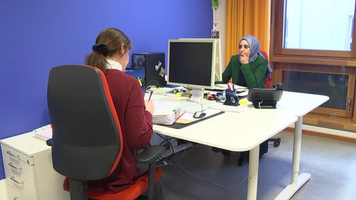 Zu sehen sind zwei Bildungsberaterinnen des Quartiersbildungszentrums in Bremen, welche in ihrem Büro sitzen.