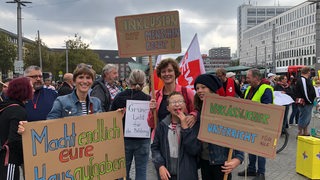 Menschen demonstrieren am Bremer Hauptbahnhof für mehr Bildung