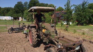Zu sehen ist der Traktor eines Biobauern auf einem Feld.