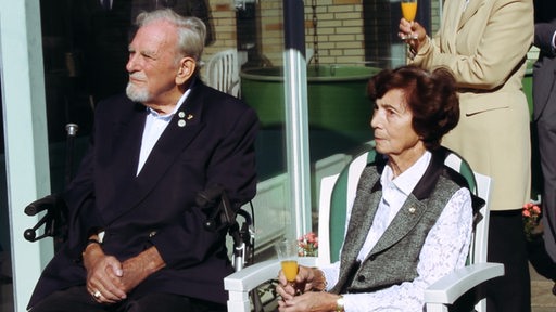 Ein alter Mann und eine alte Frau sitzen in der Sonne