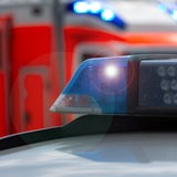 Polizeiwagen mit Blaulicht, im Hintergrund sieht man einen Rettungswagen
