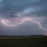 Ein Blitz zuckt am Abend über dem Himmel 
