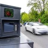 Mobiler Blitzer steht auf einer Landstraße, Auto fährt vorbei