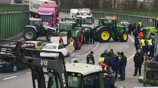 Einige Bauern blockieren mit ihren Traktoren eine Autobahn.
