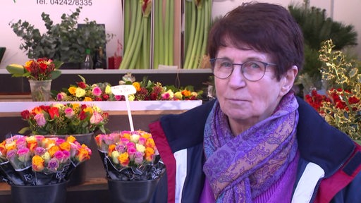 Die langjährige Floristin Helga Reinhardt vor einigen ihrer Blumenregale.