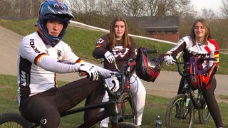 Die drei Geschwister aus Bremerhaven sitzen auf ihren BMX Bikes. 