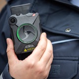 Eine Hand hält eine Bodycam. 