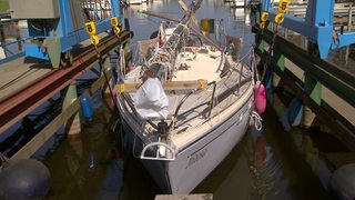 Ein Boot wird ins Wasser gekrant.