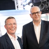 Andreas Bovenschulte und Frank Imhoff stehen gut gelaunt nebeneinander und gucken ins Bild