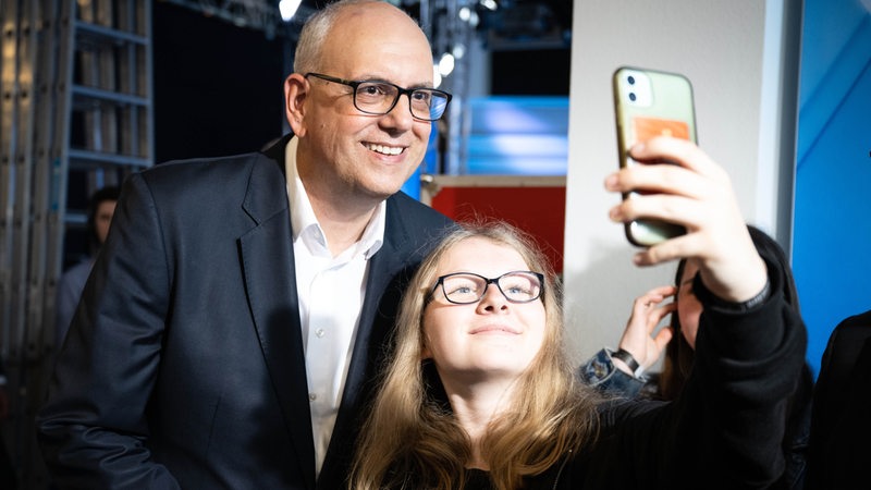 Andreas Bovenschulte, Spitzenkandidat der SPD in Bremen, macht nach Bekanntgabe der ersten Prognose für die Wahl zur Bremischen Bürgerschaft ein Selfie mit einer SPD-Anhängerin.