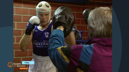 Ein Boxer der mit seinem Trainer trainiert.