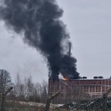 Qualm und Flammen dringen aus einem Backsteingebäude