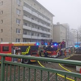 Drei Feuerwehrautos stehen vor einem Gebäude.