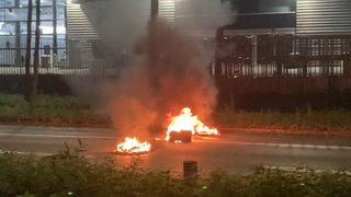 Brennende Reifen sind auf der Hollerallee vor der Messe Bremen zu sehen