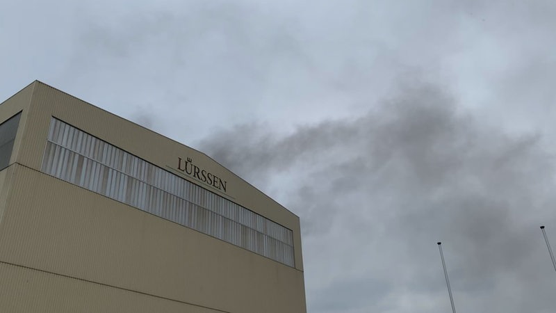 Aus einem Gebäude der Bremer Lürssen-Werft in Lemwerder steigt Qualm auf.