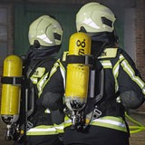 Zwei Feuerwehrleute stehen vor einem Stall.
