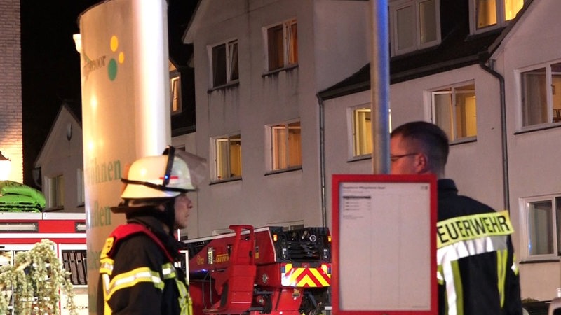 Feuerwehrleute arbeiten vor einem Seniorenheim. 