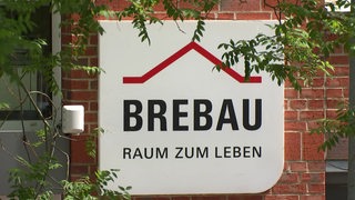 Ein Außenschild der Brebau an einer Hausfassade.