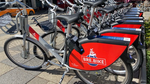 Leihfahrräder mit der Aufschrift Bre.Bike stehen in einer Reihe.