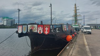 Im Bremerhavener Fischereihafen liegt die beschädigte Kogge "Ubena" im Wasser.