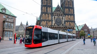 Eine Straßenbahn der BSAG fährt vor dem Bremer Dom entlang.