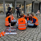 Protestierende der letzten Generation sitzen im Kreis vor der Bremer Bürgerschaft