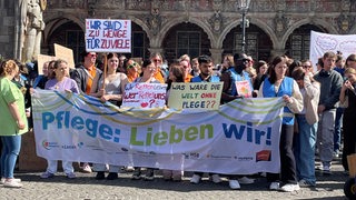 Auf dem Bremer Marktplatz demonstrieren mehrere Pflege-Beschäftigte.
