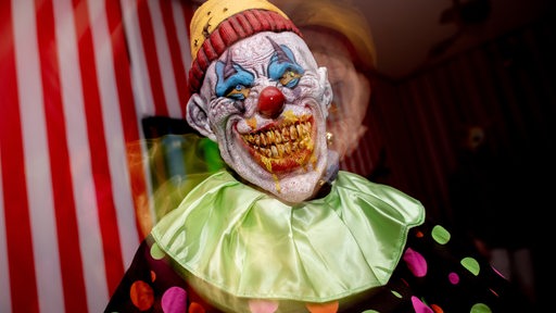 Ein Horror-Clown in einem Spuk-Haus an Halloween