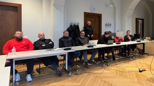 Am Landgericht Bremen sitzen mehrere Angeklagte und ihre Anwälte hinter Tischen.