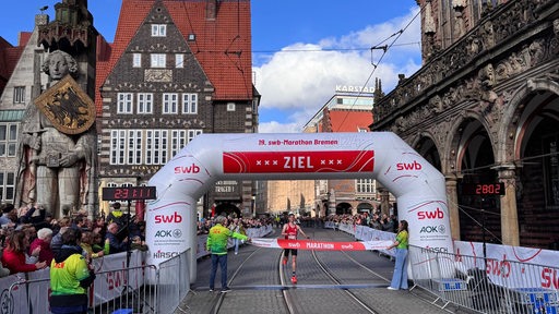 Leonard Maisch kommt als Sieger des 19. Bremen-Marathons auf dem Marktplatz vor dem Rathaus ins Ziel.