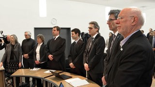 Mehrere Personen in einem Saal des Oberverwaltungsgerichts.