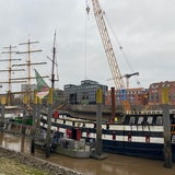 An dem an der Bremer Schlachte liegende "Pannekoekschip" wird der dritte Mast entfernt.