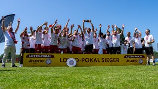 Die Spieler des FC Oberneuland feiern den Gewinn des Bremen-Pokals.