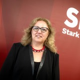 Özlem Ünsal posiert vor einem SPD-Wappen.
