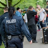 Polizisten gehen an Vatertag-Feiernden vorbei. 