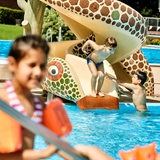 Ein Kind springt in einem Freibad ins Wasser