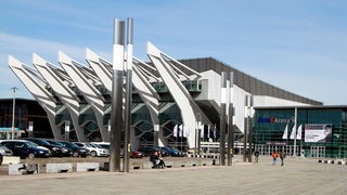 Blick auf die Bremer Stadthalle und auf den Parkplatz, auf dem zahlreiche Autos stehen.