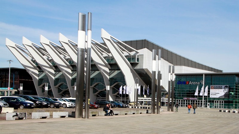Blick auf die Bremer Stadthalle und auf den Parkplatz, auf dem zahlreiche Autos stehen.