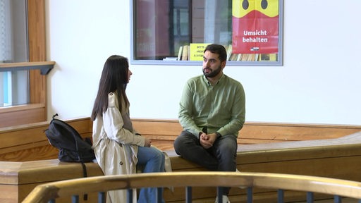Ein Lehrer im Gespräch mit seiner Schülerin
